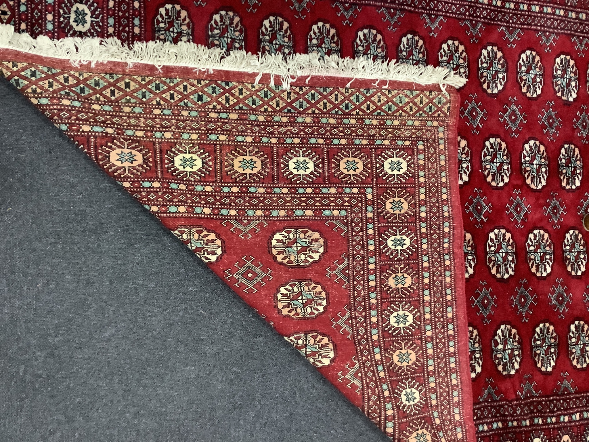 A Bokhara red ground rug, 246 x 152cm